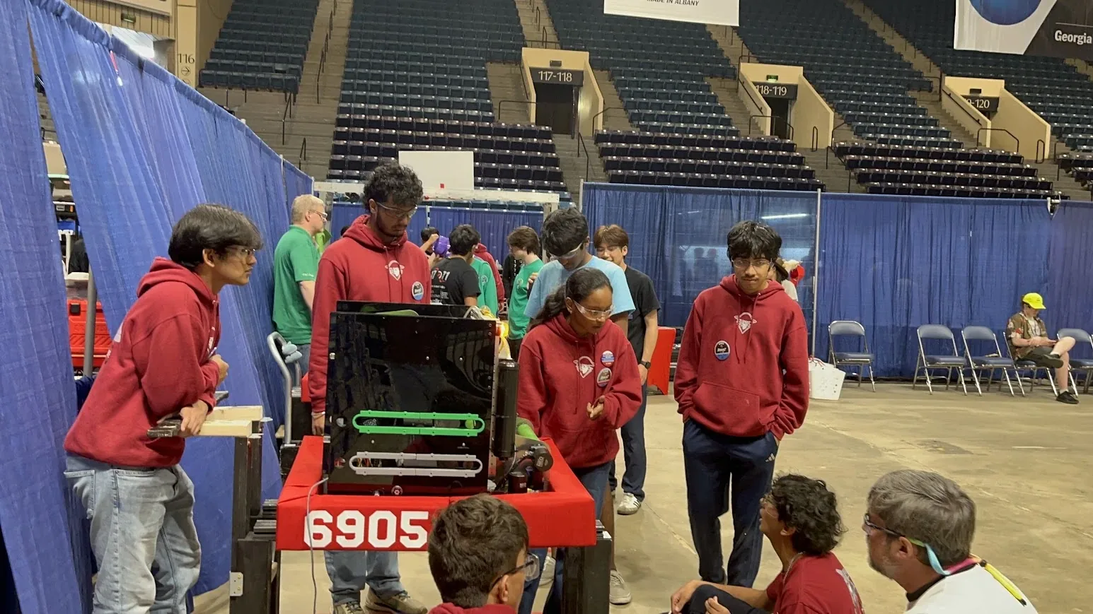 Team members gathered around the robot in the arena