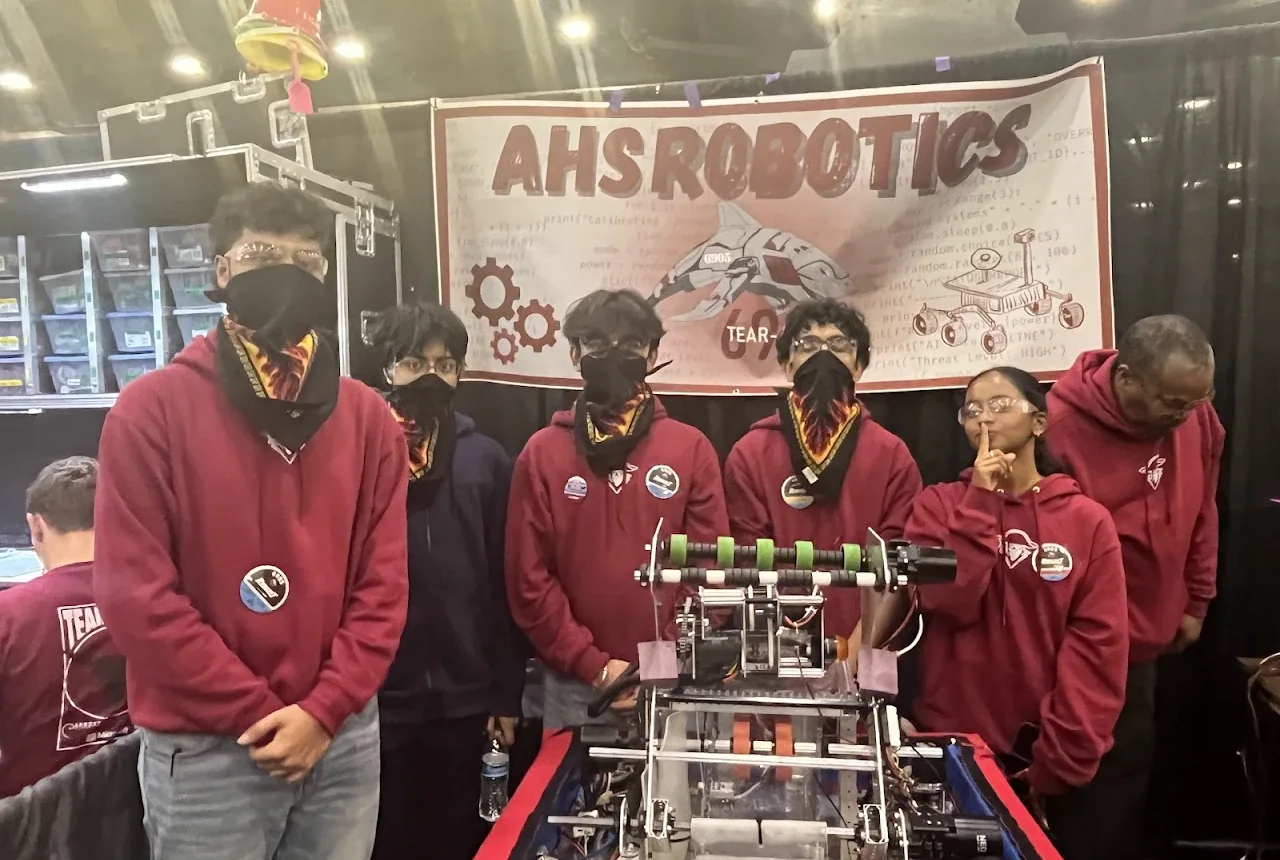 Tear-A-Byte team members with the robot in front of the AHS Robotics banner
