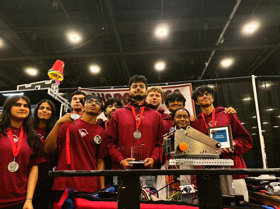 FRC team members holding their medals and trophy at an event