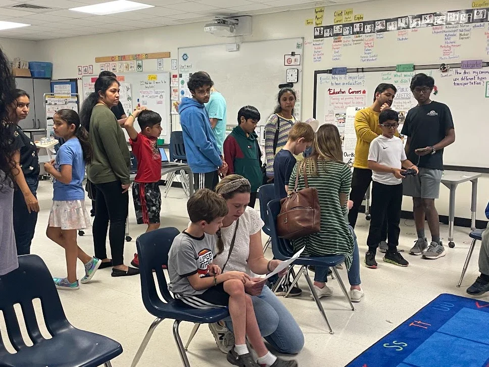 Club members and families at a classroom outreach event