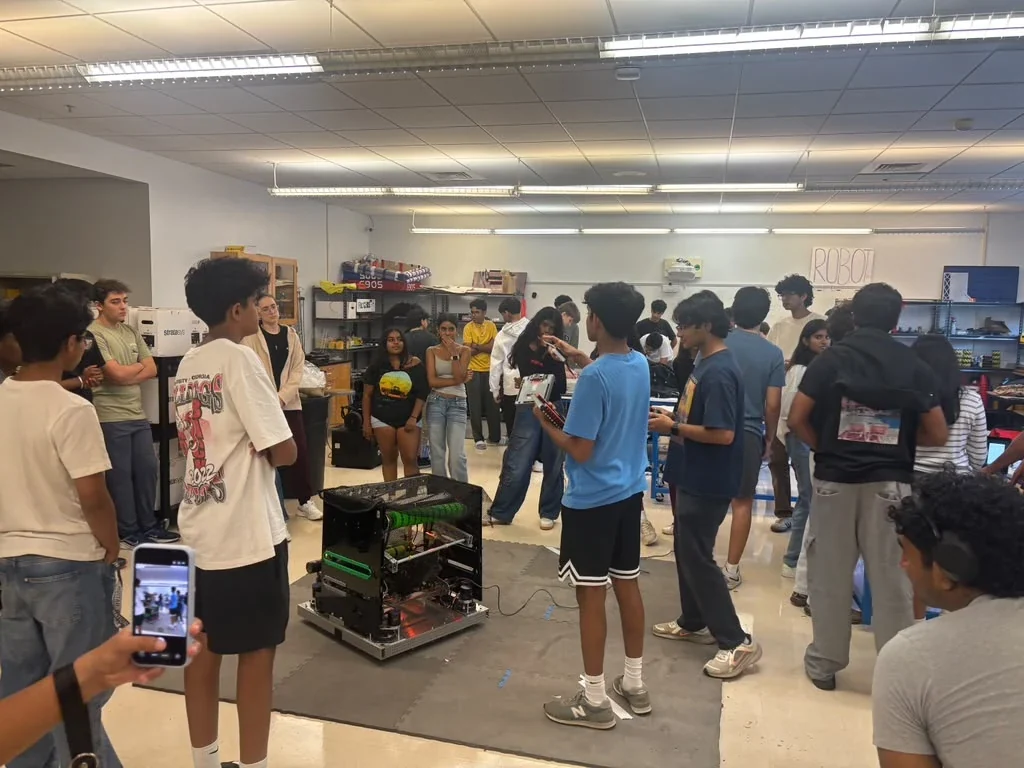 Students gathered around the 6905 robot in the robotics lab