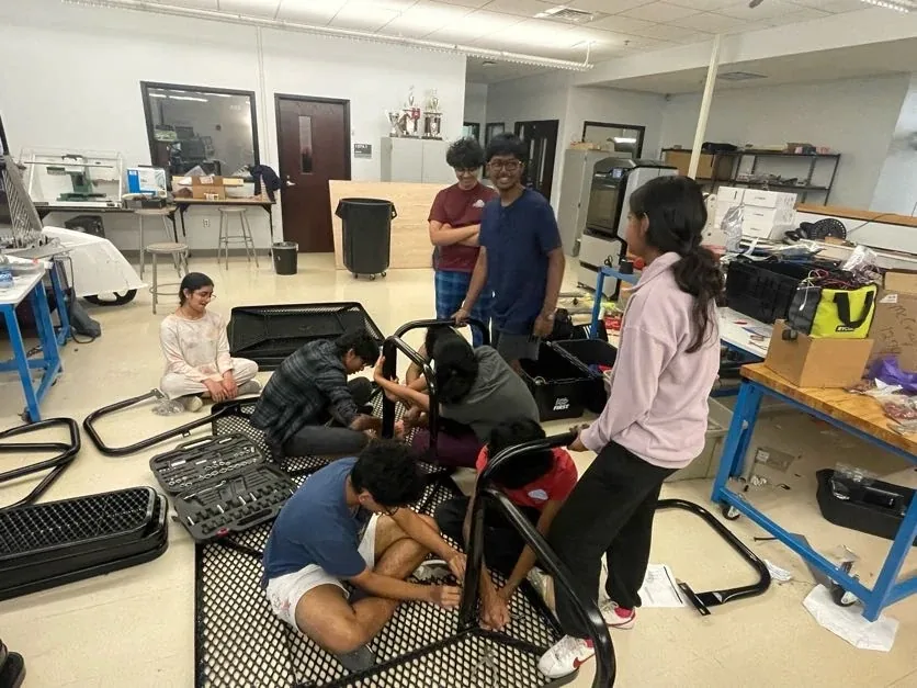 Club members assembling equipment together in the robotics lab