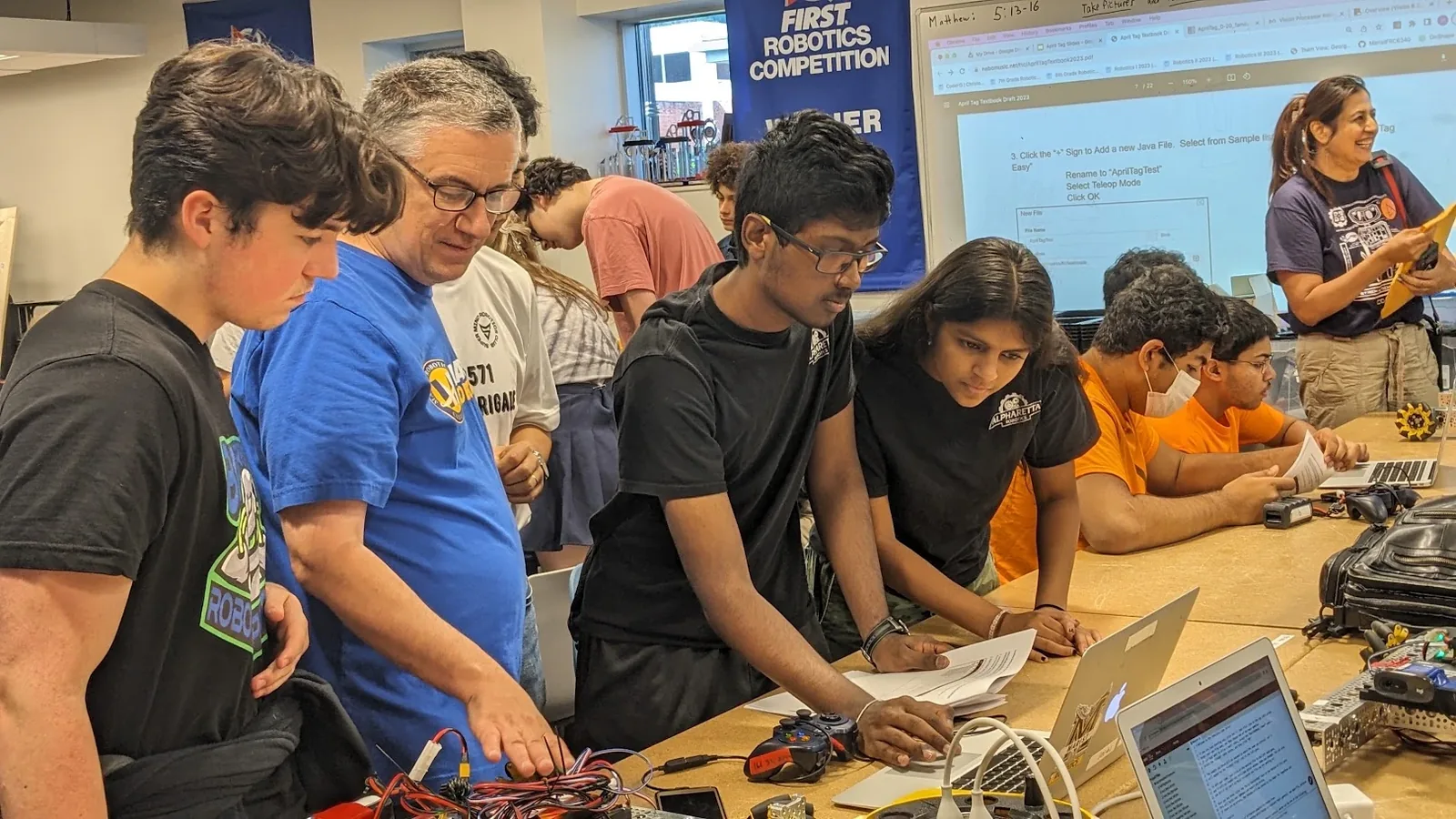 Mentors and students working through programming material together