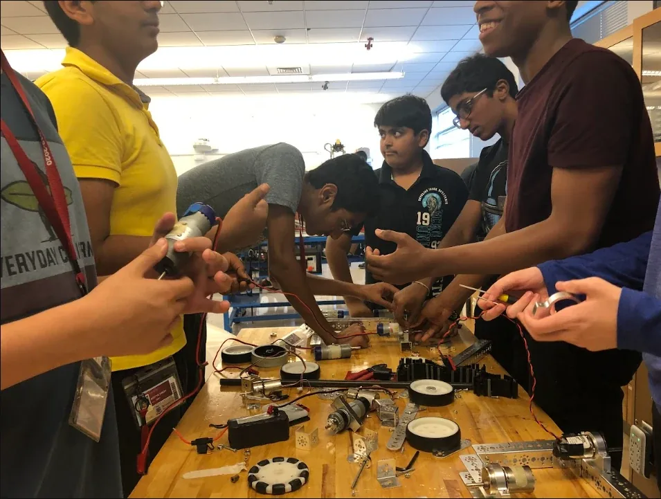 Students wiring motors and drivetrain parts at a workshop